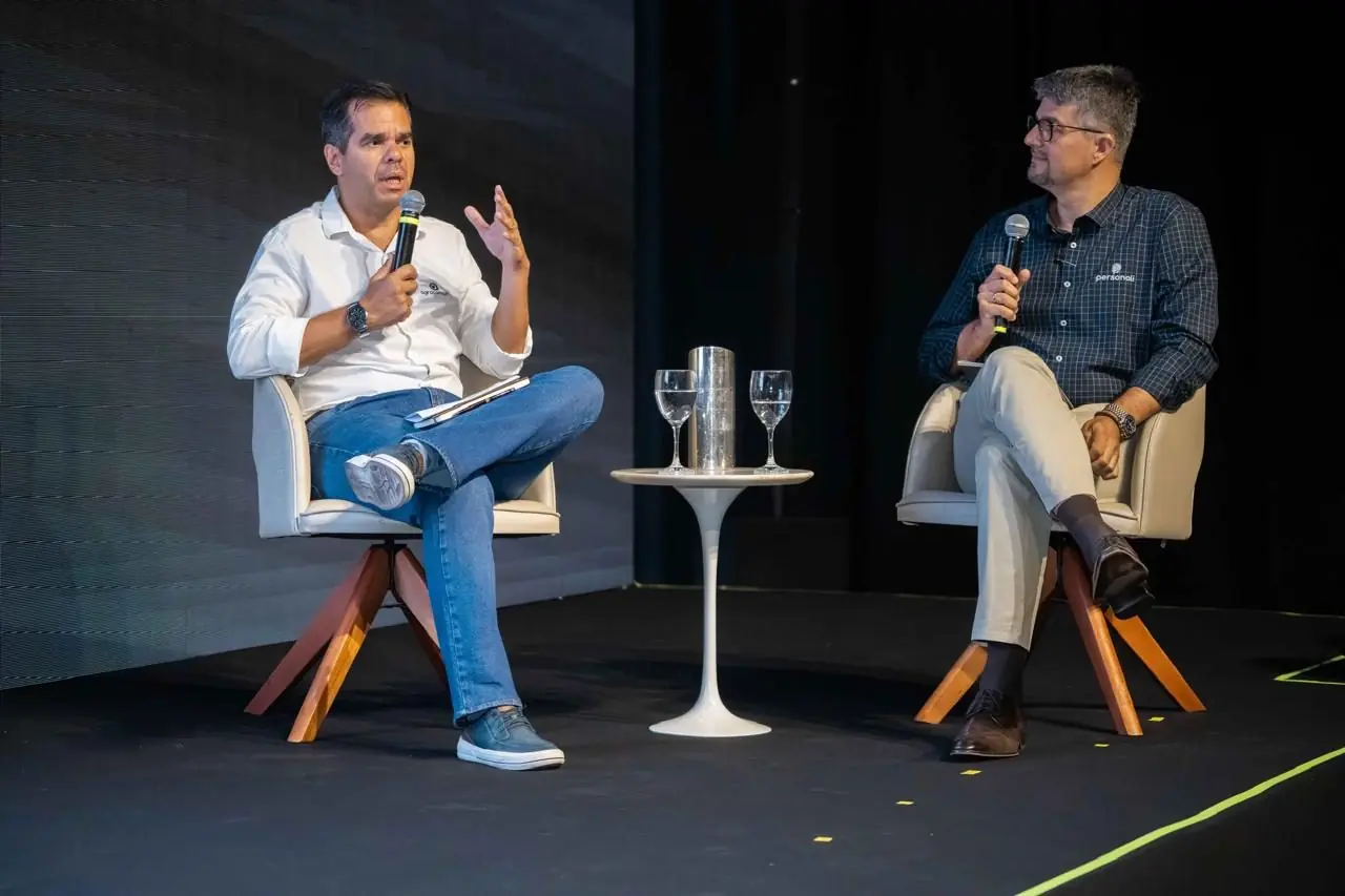 Painel mediado em palco com dois convidados